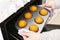 Caucasain woman holding tray with freshly made cupcakes or maffins at the kitchen