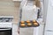 Caucasain woman holding tray with freshly made cupcakes or maffins at the kitchen