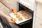 Caucasain woman holding tray with freshly made cupcakes or maffins at the kitchen