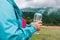 caucasian 50s blonde girl drinking water from plastic bottle. Mountain background