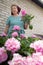 Caucasian adult woman caring for flowers, picking a bouquet in the garden,,
