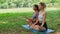 Caucasian and african american woman friends enjoying having yoga and meditation together in park