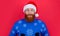caucasian amazed man in new year sweater and santa hat isolated on red background.