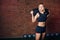 Caucasian athletic woman working out with sandbag while exercises in the gym.