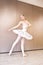 Caucasian ballet dancer practice ballet positions in professional tutu skirt of white swan. young beautiful woman ballet dancer in