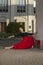 Caucasian Ballet Dancer in Red and Black Dress Posing in Dance Pose With Lifted Hands Against Pillars Outdoor