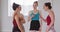Caucasian ballet female dancers standing together, chatting and laughing during a ballet class