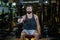 Caucasian beard muscular sport man is practice weight training on dumbbell for biceps and triceps muscle inside gym with dark