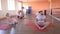 A caucasian beautiful girl trainer conducts a group yoga class among male friends in a modern fitness center, developing