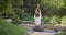 Caucasian beautiful sporty slim young woman doing yoga Physical training outdoors in the park