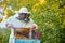 Caucasian bee master on apiary wearing protective suit and mask