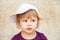 Caucasian blond baby girl in baseball cap