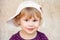 Caucasian blond baby girl in white baseball cap