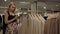 Caucasian blond female examining clothes in shop