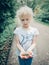 Caucasian blonde child girl holding small forest garden snails in palm hands.