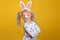 Caucasian blonde girl in white dress with pink Easter bunny ears
