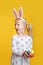 Caucasian blonde girl in white dress with pink Easter bunny ears