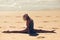 Caucasian blonde woman practicing yoga in the beach