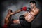 Caucasian boxer making kick in defense to african american boxer who making yap punce in kick boxing or muay thai fight match,