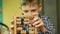 Caucasian boy of 7-8 years old wearing glasses learns to count on the abacus. Accounting theme performed by a child. Economic educ