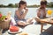 Caucasian boy and girl eating watermelon at picnic by the river