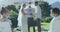 Caucasian boy and girl in face masks watching happy couple getting married outdoors