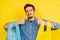 Caucasian boy holding recyclable, foldable and reusable shopping bags on a yellow background