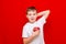 Caucasian boy kid child schoolboy holds a red Apple in his hands. Vitamins and fruits, healthy food. bright red wall
