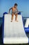 Caucasian boy of nine year old having fun at the inflatable beach aqua slide