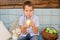 Caucasian  boy of nine  year old sits on a garden swing and eat green apples. Happy smiling child, carefree childhood in the