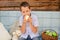 Caucasian  boy of nine  year old sits on a garden swing and eat green apples. Happy smiling child, carefree childhood in the