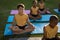 Caucasian boy practicing yoga and meditating sitting on yoga mat in garden at school