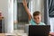 Caucasian boy raising hand while attending online class over laptop at home, copy space