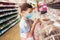 Caucasian boy in sanitary face mask shopping sweets. Child wearing protective mask against coronavirus. Safety,