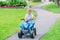 Caucasian boy toddler driving blue electric car on the road