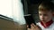 Caucasian boy traveling by train uses a smartphone while sitting by the window. The child goes on vacation by train in the summer.