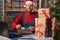 Caucasian business owner working with product packaging and laptop wearing a Sanat Claus hat and red sweater. Glue