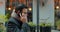 Caucasian businessman in glasses walking the street and talking on the phone. Handsome male speaking on mobile phone and