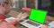 Caucasian businessman on laptop video call with green screen