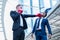 Caucasian businessman wear red boxing gloves punch to face of asian businessman. concept of business competition