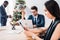 caucasian businessman working and multicultural colleagues decorating christmas tree