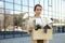 Caucasian businesswoman carrying wooden box with personal stuff while leaving office center. Portrait jobless woman who