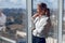 Caucasian businesswoman standing in office and looking out of window. Mature woman looking away