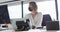 Caucasian businesswoman wearing face mask and sitting at desk at work