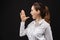 Caucasian businesswoman in a white shirt on a black background. Gesture depicting a scream, announcement