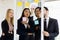Caucasian Businesswomen and Asian Businessmen smiling explaining working smilling and on a board, having post-it papers at the