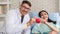 Caucasian cardiology doctor and asian patient holding heart shape ball together in concept of heart attack prevention campaign