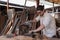 Caucasian carpenter wearing a safety goggle and cutting wood on a table saw in a carpentry shop