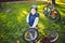 Caucasian child boy in a helmet learns to repair his bike. Child cyclist checks the mechanism of a bicycle in a clearing of green