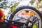 Caucasian child boy in a helmet learns to repair his bike. Child cyclist checks the mechanism of a bicycle in a clearing of green